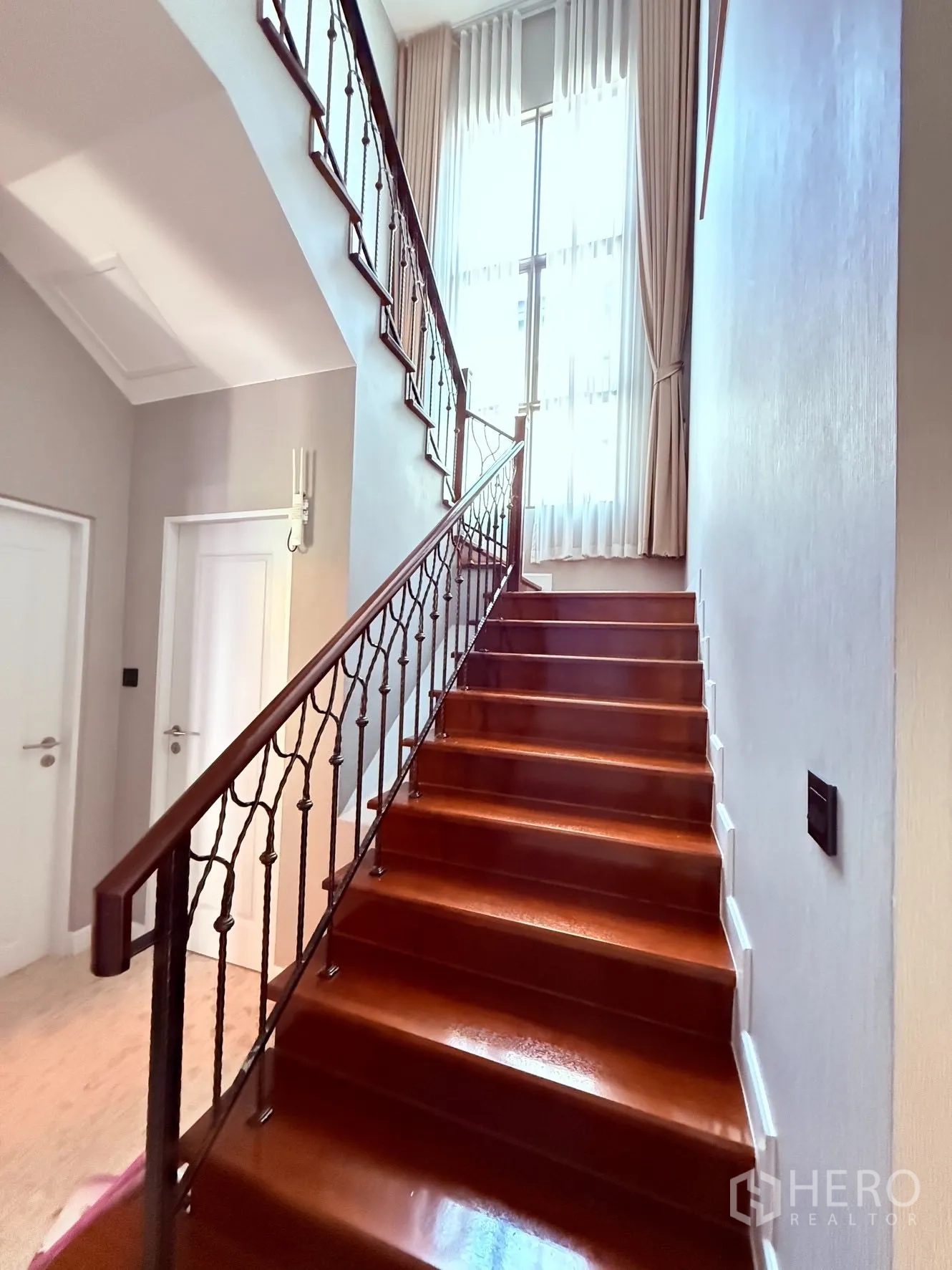 บ้านเดี่ยว for rent or sale in Prawet, Bangkok - บันไดไม้พร้อมราวเหล็กดัดและหน้าต่างสูงรับแสงธรรมชาติ.