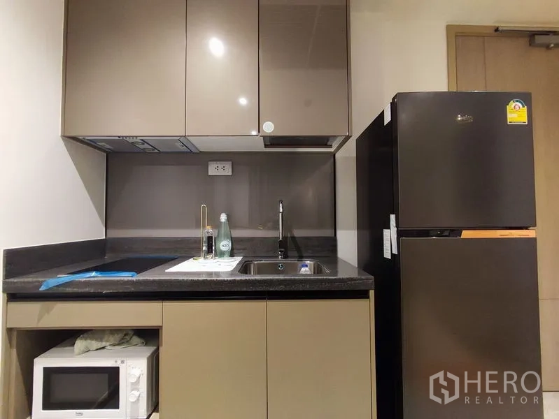 คอนโด ให้เช่าในDin Daeng, Bangkok - ภาพระยะใกล้ของครัวแคบ มีอ่างล้างจาน ไมโครเวฟ ตู้แขวน และตู้เย็น