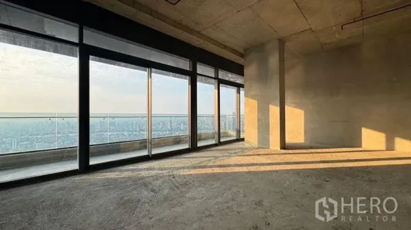 Condominium for sale in Bangkok - Large shell-condition room with sliding glass doors, natural light and wide panoramic skyline view.