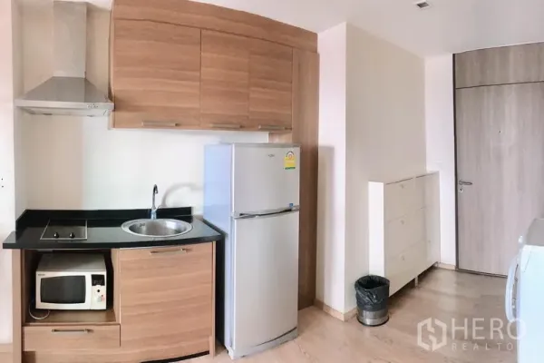 公寓 出租在Khlong Toei, Bangkok - 厨房近景，含炉灶、抽油烟机、水槽、冰箱与收纳柜