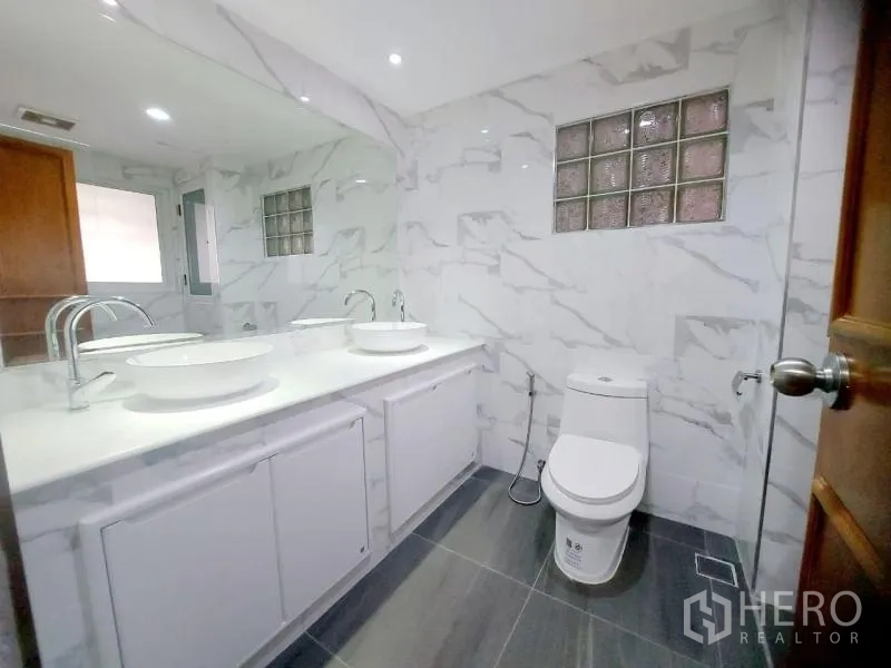 คอนโด ให้เช่าในWatthana, Bangkok - ห้องน้ำอีกห้อง พร้อมอ่างล้างหน้าคู่ ผนังลายหินอ่อน และโถสุขภัณฑ์ข้างโซนอาบน้ำ