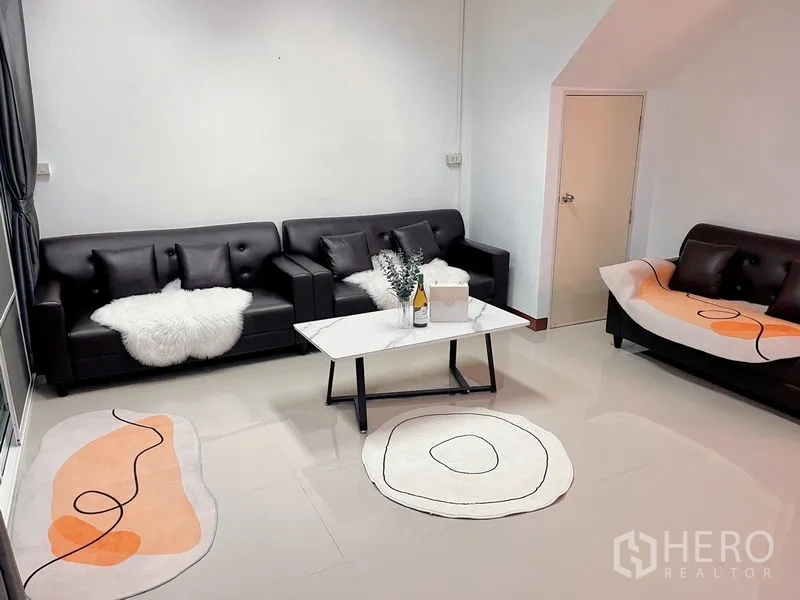 ทาวน์เฮาส์ ให้เช่าในHuai Khwang, Bangkok - โซนที่นั่งพร้อมโซฟา 3 ตัว พรมสไตล์โมเดิร์น และโต๊ะกลาง