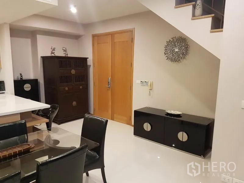 คอนโด ให้เช่าหรือขายในKhlong Toei, Bangkok - โถงทางเข้าพร้อมประตูไม้ ตู้เก็บของ และบันได ในคอนโดสมัยใหม่