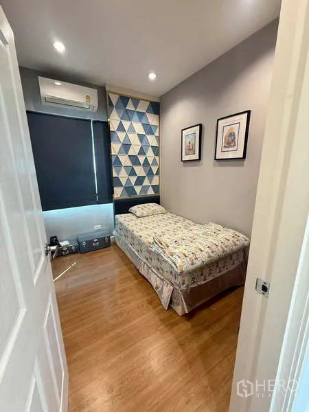 独立式住宅 出售在Bang Khen, Bangkok - 小卧室，带空调，几何图案背景墙与遮光窗帘。