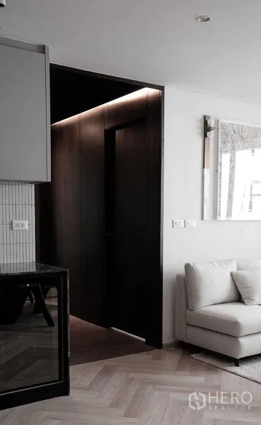 คอนโด ขายในRatchathewi, Bangkok - โถงทางเดินไม้สีเข้มตัดกับห้องนั่งเล่นที่สว่าง