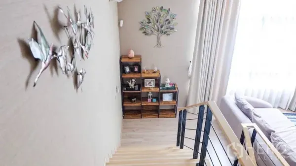 ทาวน์เฮาส์ ให้เช่าหรือขายในSuan Luang, Bangkok - โถงบันไดสว่าง แต่งผนังด้วยงานอาร์ตและชั้นไม้ ผ้าม่านสูงจรดเพดาน