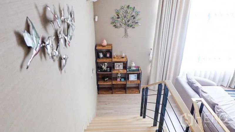 ทาวน์เฮาส์ ให้เช่าหรือขายในSuan Luang, Bangkok - โถงบันไดสว่าง แต่งผนังด้วยงานอาร์ตและชั้นไม้ ผ้าม่านสูงจรดเพดาน