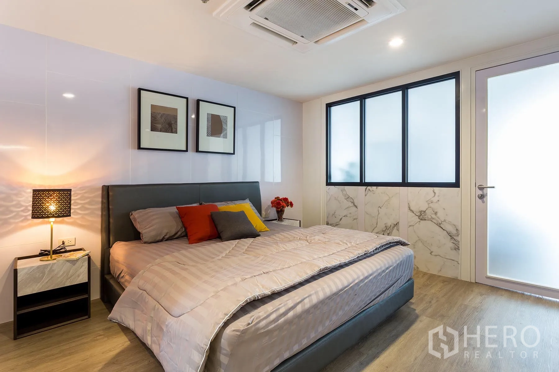 公寓 出租在Watthana, Bangkok - 明亮卧室，配特大床与床头灯，磨砂玻璃與大理石裝飾。