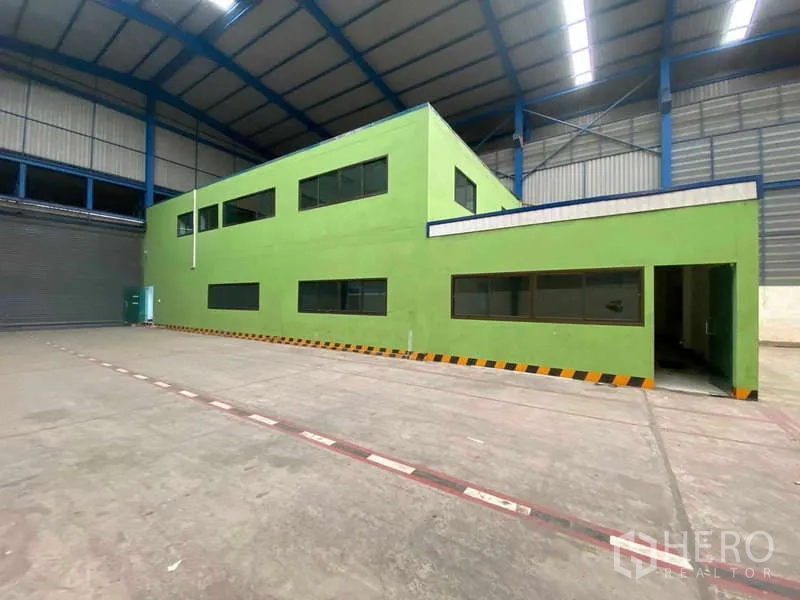 Warehouse for rent in Lat Lum Kaeo, Pathum Thani - Internal two-storey office unit inside warehouse beneath high truss roof.