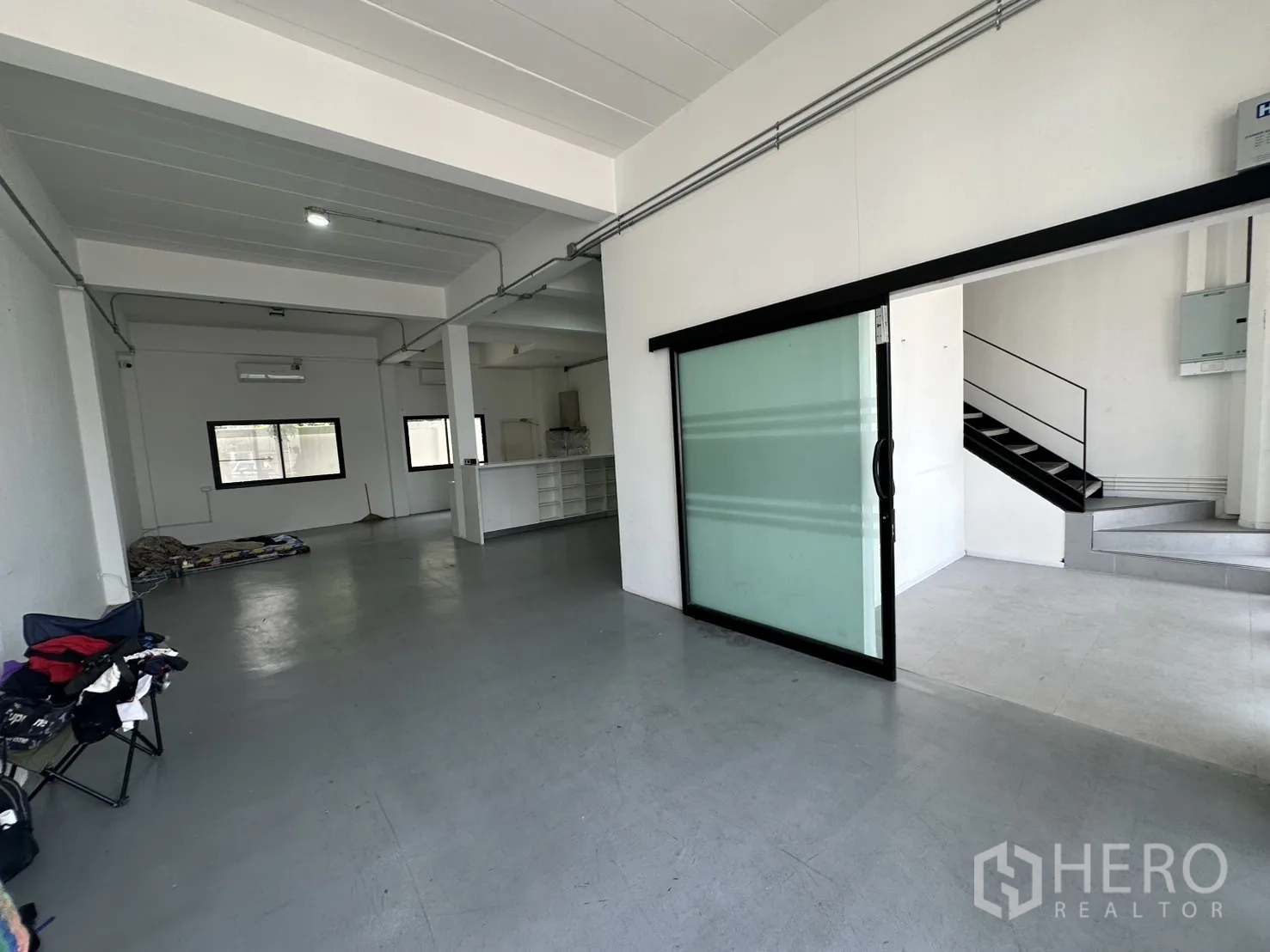 带办公室的家 出租或出售在Bang Na, Bangkok - 一层开放式空间，滑动玻璃隔断与金属楼梯