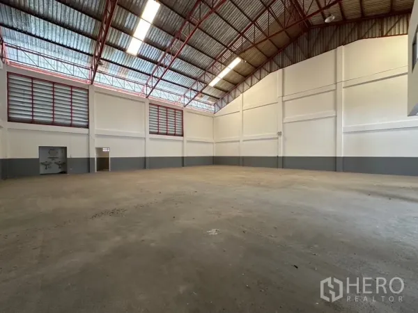 Factory for rent in Bang Sao Thong, Samut Prakan - Spacious warehouse floor with high steel‑truss roof, skylights and ventilation louvres.