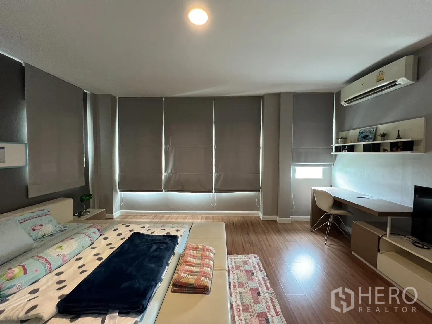 Detached House for rent in Bang Kapi, Bangkok - Master bedroom corner with study desk, air conditioner and wall shelves.