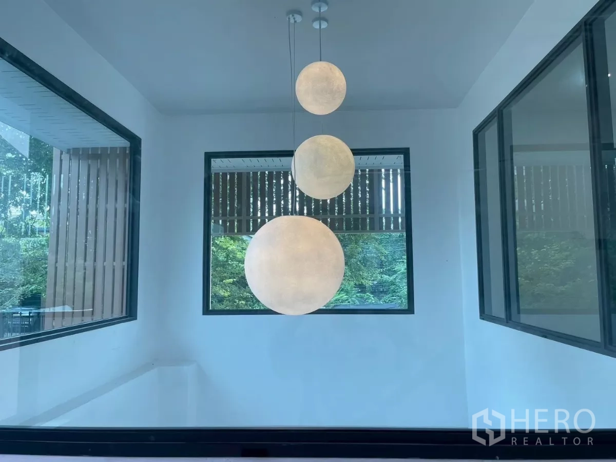 独立式住宅 出售在Prawet, Bangkok - 双层挑空里的三球吊灯，被窗户框景。