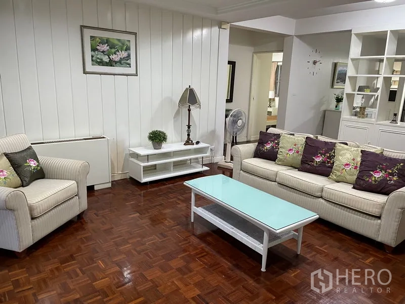 อพาร์ทเมนท์ ให้เช่าในWatthana, Bangkok - ห้องนั่งเล่นพร้อมโซฟาลายทาง โต๊ะกลางกระจก และพื้นไม้ปาร์เกต์
