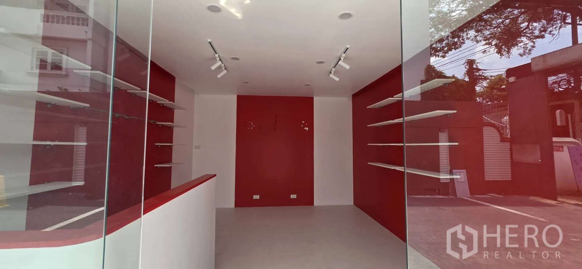 Retail Space for rent in Watthana, Bangkok - Open retail room with shelves on both sides, red feature walls, and track lighting.