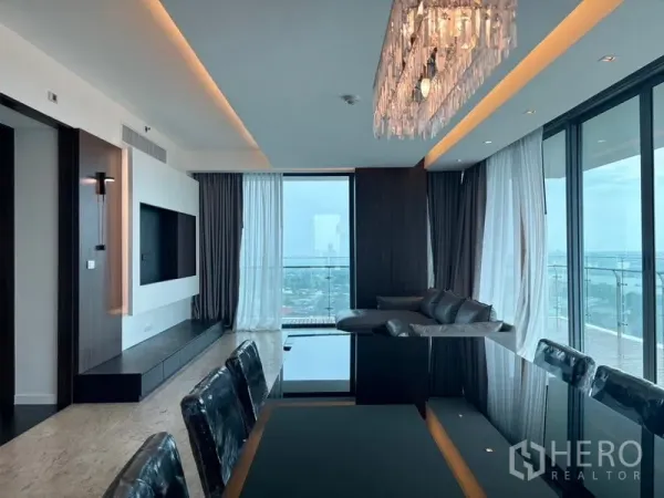Condominium for rent - Open-plan living and dining with a crystal chandelier, floor-to-ceiling windows and balcony overlooking the city and Chao Phraya River.