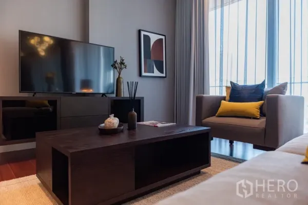 คอนโด ขายในWatthana, Bangkok - มุมพักผ่อนพร้อมเก้าอี้อาร์มแชร์ โต๊ะกลาง และทีวีจอแบนขนาดใหญ่
