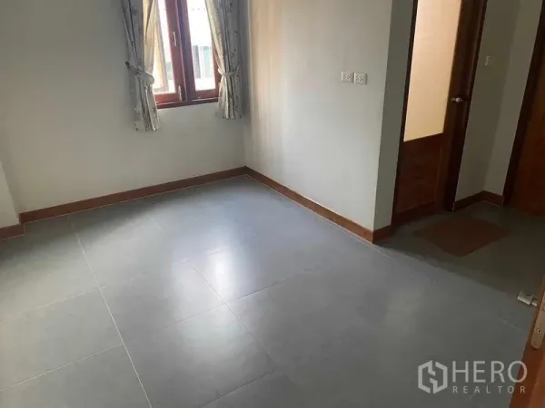 Detached House for sale in Bang Khun Thian, Bangkok - Bright empty bedroom with gray tile floor, curtained window and wooden doors.