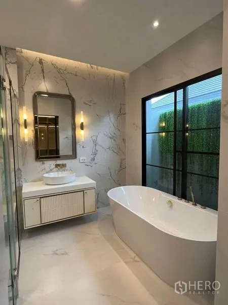 Detached House for rent in Saphan Sung, Bangkok - Luxury marble bathroom with freestanding soaking tub, vanity and picture window.