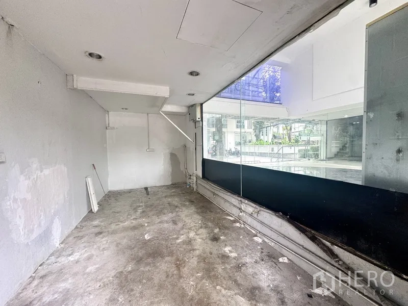 Retail Space for rent in Sathon, Bangkok - Unfinished back room with concrete floor and large display window into the atrium.
