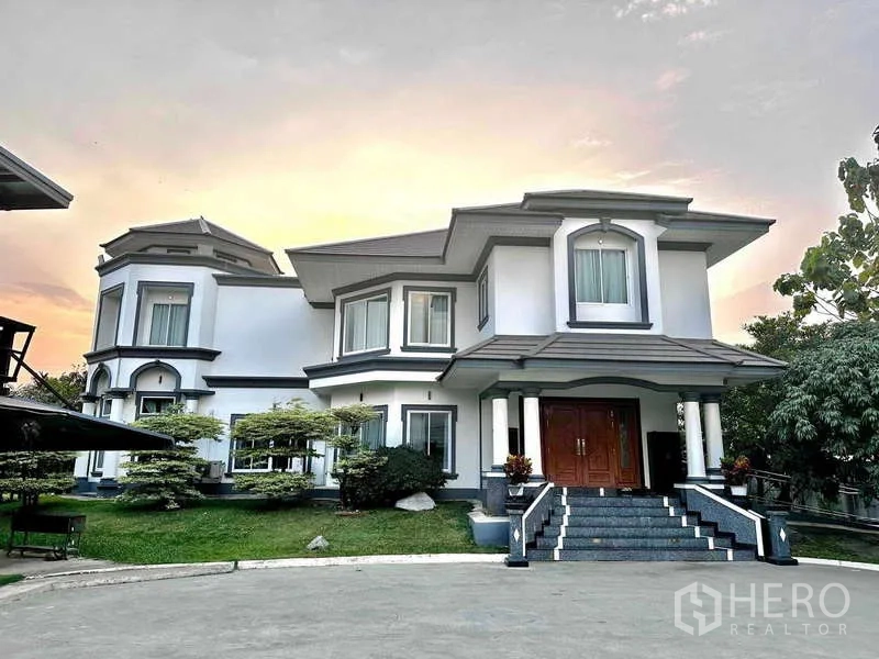 บ้าน ขายในKhlong Luang, Pathum Thani - ประตูทางเข้าบ้านเดี่ยวแบบประตูไม้คู่ พร้อมเสาเฉลียงและสวนจัดแต่ง