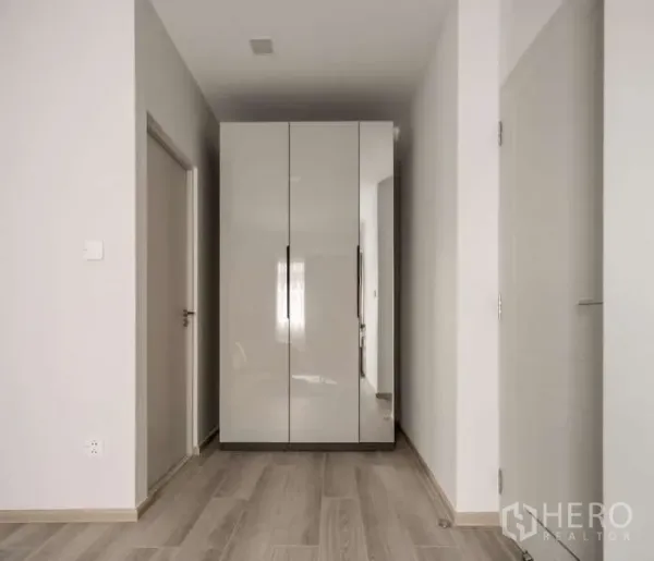Detached House for rent or sale in Bang Phli, Samut Prakan - Hallway with glossy built-in wardrobe and light wood floors.
