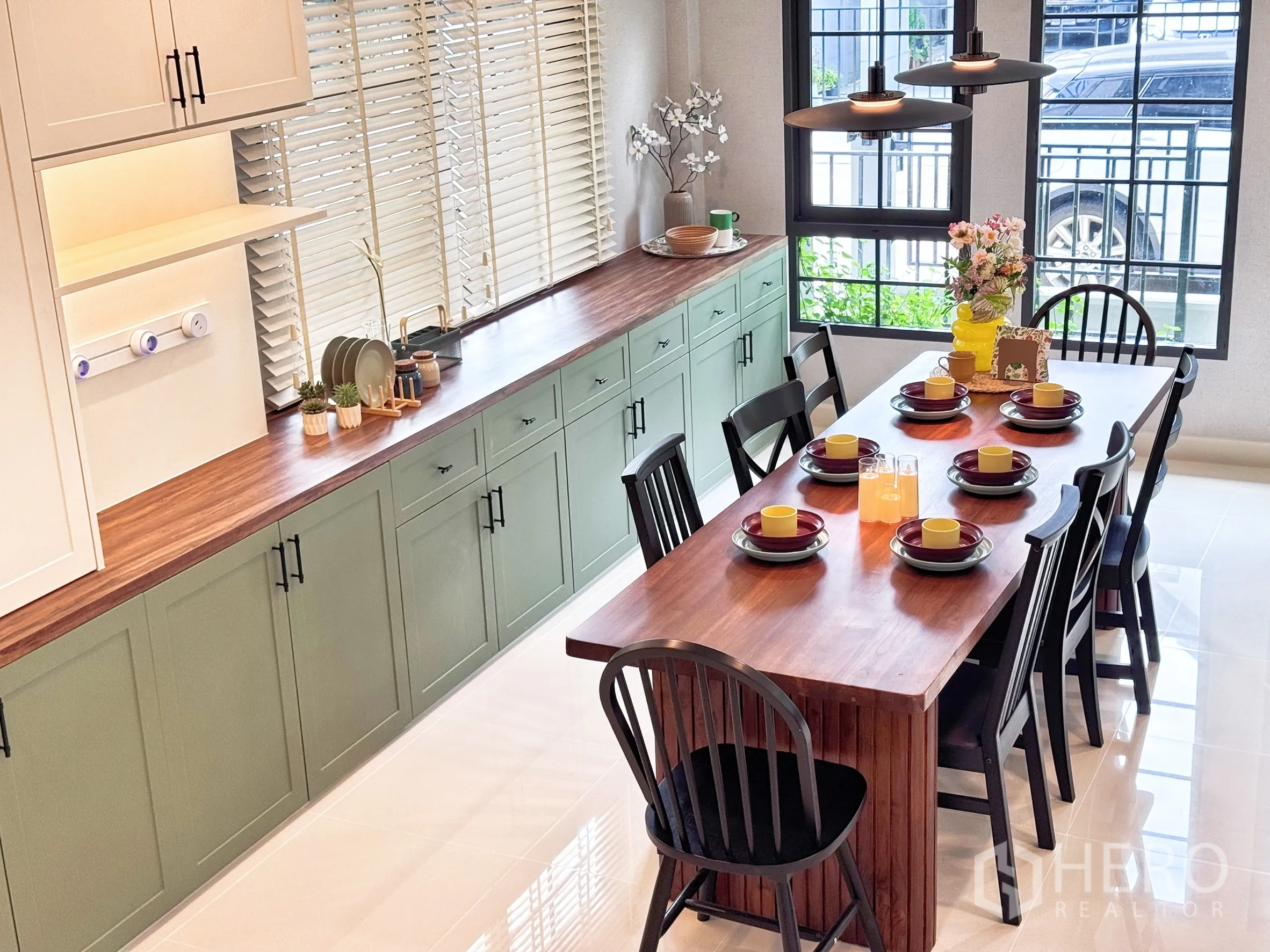 Detached House for rent in Bang Phli, Samut Prakan - Close-up of cabinetry with wood countertop and dining table arranged with tableware.