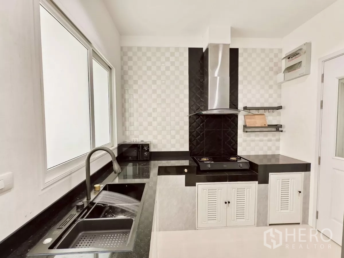 独立式住宅 出租在Khlong Luang, Pathum Thani - 现代泰式厨房，黑色花岗岩台面、燃气灶与不锈钢烟机