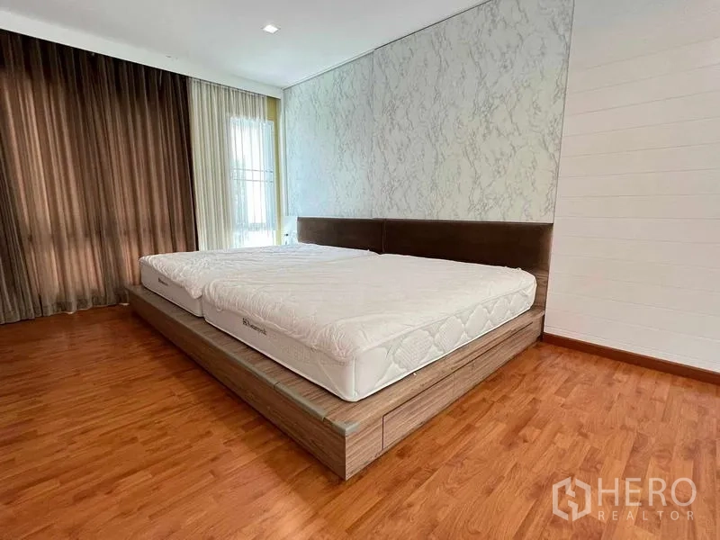 บ้าน ขายในBang Kruai, Nonthaburi - ห้องนอนกว้าง เตียงยกพื้น พื้นไม้ และหน้าต่างมุมพร้อมผ้าม่าน