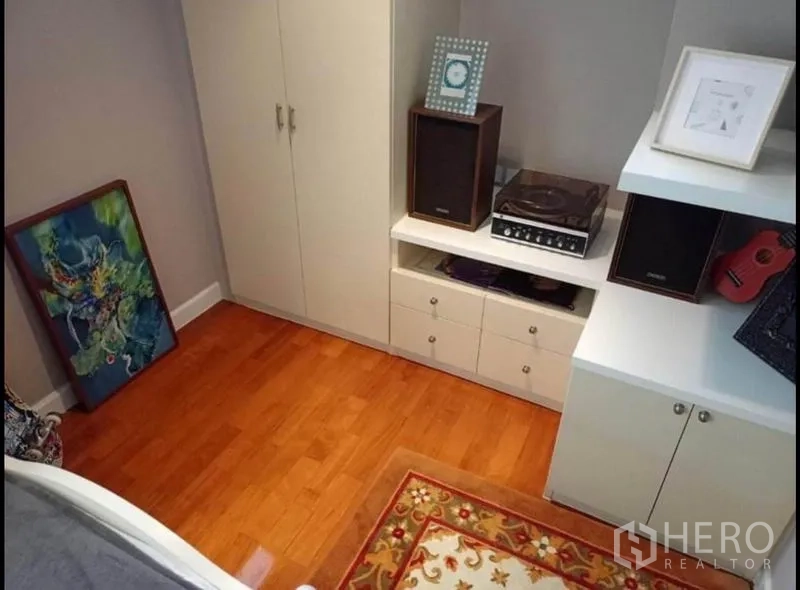 คอนโด ให้เช่าหรือขายในKhlong Toei, Bangkok - มุมห้องนอนพร้อมตู้เสื้อผ้าบิวท์อิน ตู้เก็บของสีขาว และพื้นไม้จริงโทนอุ่น