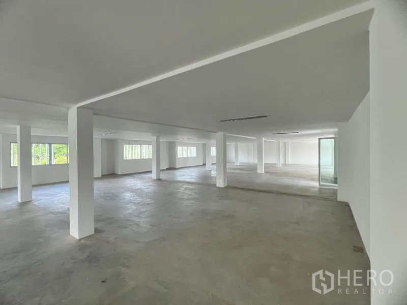 零售空间 出租在Huai Khwang, Bangkok - 采光良好的开放式零售楼层，多个窗户、白色立柱与玻璃入口门。