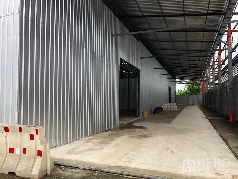 货栈 出租在Pak Kret, Nonthaburi - 带雨棚的侧向通道与金属外墙，方便卡车进出装卸