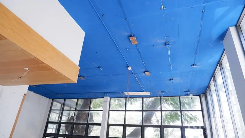 零售空间 出租在Watthana, Bangkok - 高挑天花带布线点，整面玻璃墙可见室外大树景观。