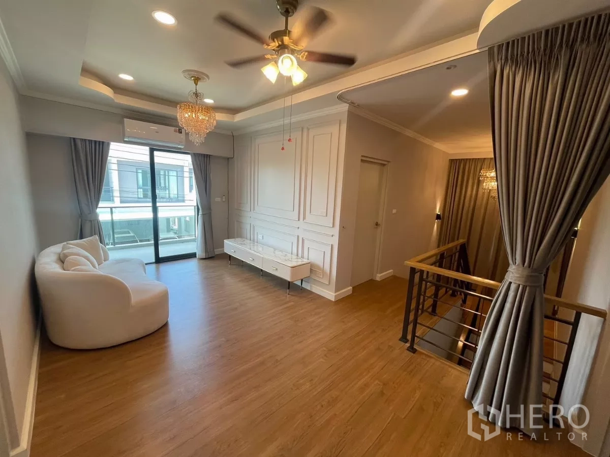 独立式住宅 出租在Bang Phli, Samut Prakan - 二层家庭厅，带阳台出入口、吊扇与沙发。