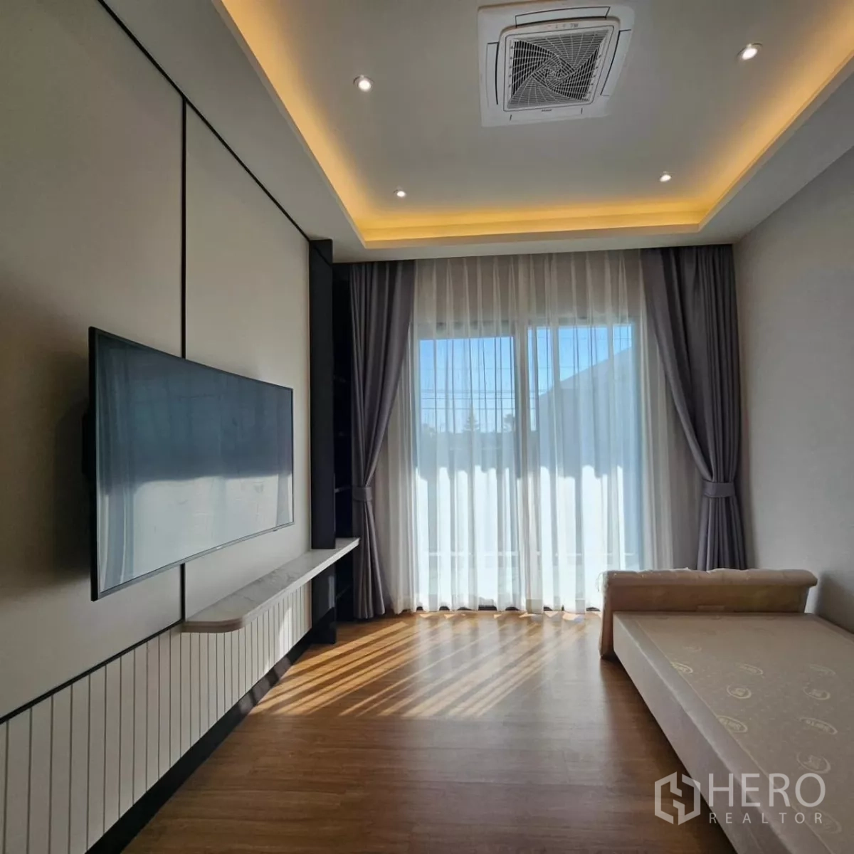 Detached House for rent in Bang Phli, Samut Prakan - Upstairs family room with wall-mounted TV, daybed and floor-to-ceiling curtains.