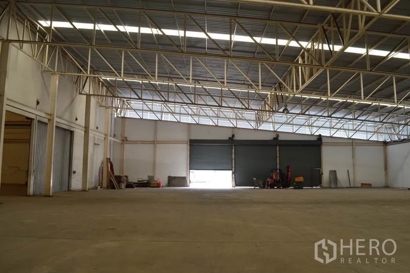 Warehouse for rent in Bang Sue, Bangkok - Warehouse loading area in Bang Sue with several roller shutter doors and expansive concrete floor for trucks.