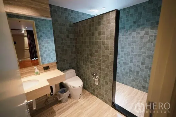 คอนโด ให้เช่าหรือขายในBang Na, Bangkok - ห้องน้ำสมัยใหม่พร้อมเคาน์เตอร์หิน อ่างล้างหน้า โถสุขภัณฑ์ และฉากกั้นกระเบื้องนำไปสู่โซนอาบน้ำ