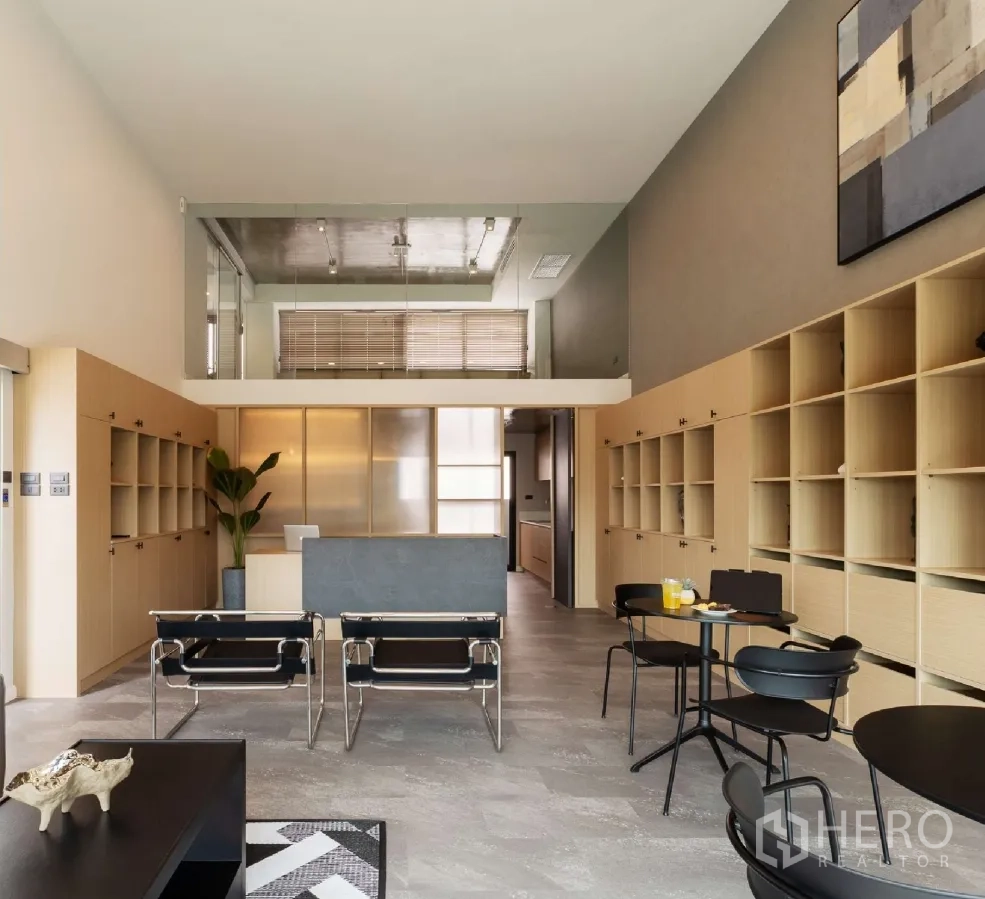 家庭办公室 for rent or sale in Bang Khen, Bangkok - 挑高接待大厅，带玻璃夹层、内置收纳与现代座椅。