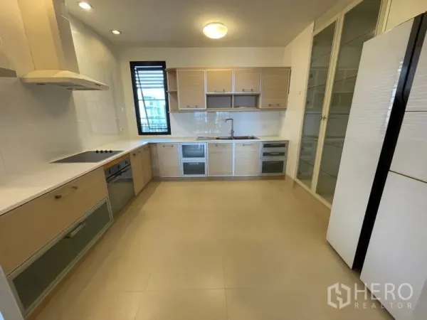 Condominium for rent in Watthana, Bangkok - Bright separate kitchen with built-in oven, electric cooktop, pantry cabinets and ample counter space.