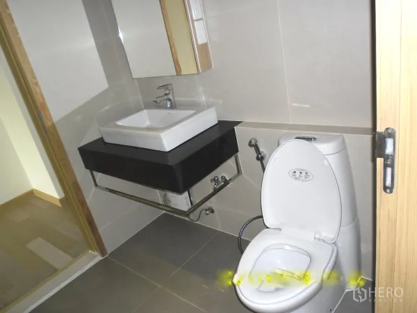 คอนโด ให้เช่าหรือขายในWatthana, Bangkok - ห้องน้ำปูกระเบื้องสะอาด พร้อมอ่างล้างหน้าแบบเหลี่ยม กระจก และโถสุขภัณฑ์ ในคอนโดกรุงเทพฯ