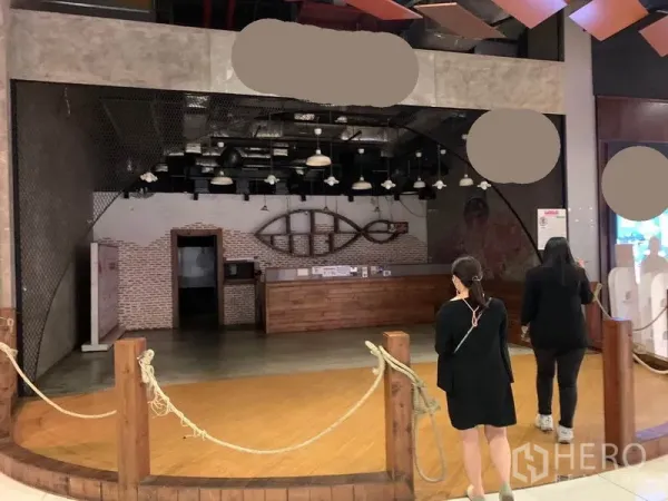 零售空间 出租在Khlong Toei, Bangkok - 商场内开放式店面，木质吧台、砖墙与工业风吊灯。