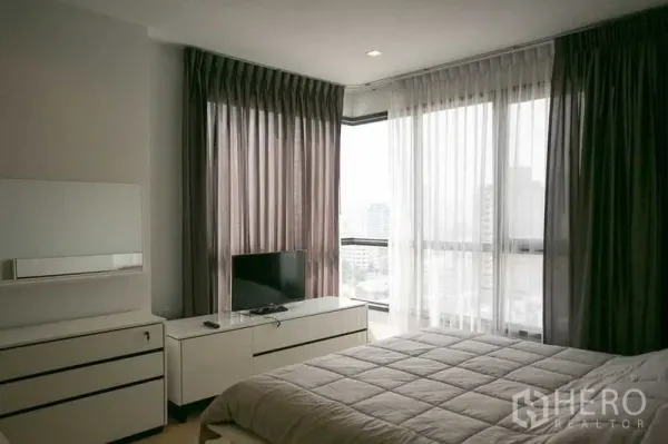 公寓 出租在Watthana, Bangkok - 转角卧室，落地窗可眺望曼谷城市景观。