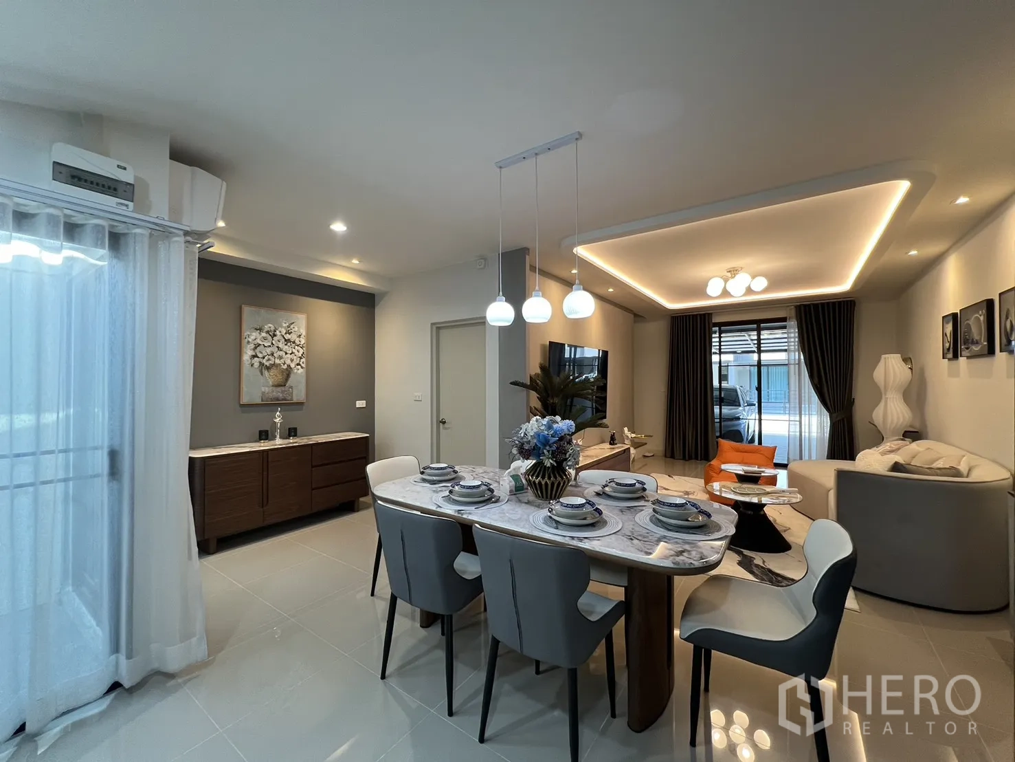 Townhouse for rent in Bang Phli, Samut Prakan - Open living-dining space with cove lighting and sliding doors to the front area.