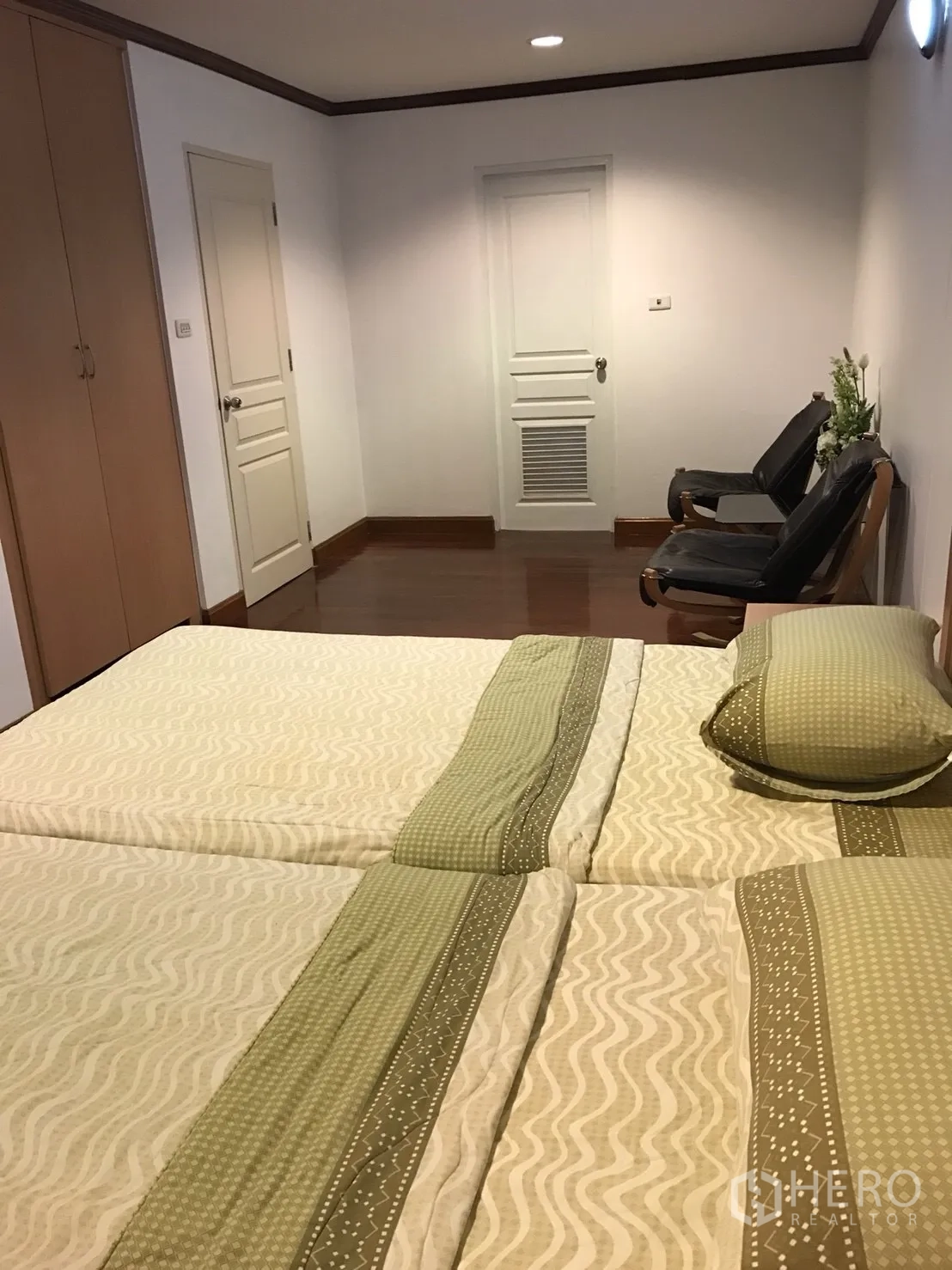 公寓 出租在Khlong Toei, Bangkok - 明亮卧室内两张床，衣柜、白色门与座椅。