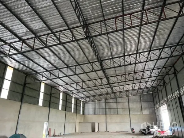Warehouse for rent in Lam Luk Ka, Pathum Thani - Wide-span storage hall with high-clearance ceiling, ventilation panels and natural light.