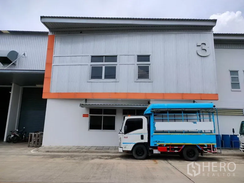 工厂 出租在Phra Nakhon Si Ayutthaya - 厂房立面设有雨棚与停车位，前方停有一辆配送卡车。