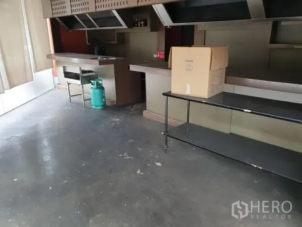 零售空间 出租在Khlong Toei, Bangkok - 商用厨房区，操作台、顶置排烟罩和燃气瓶。