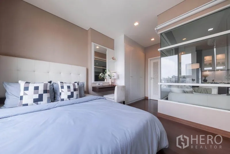 公寓 出租在Watthana, Bangkok - 卧室设玻璃隔断连接客厅，并有内置衣柜。