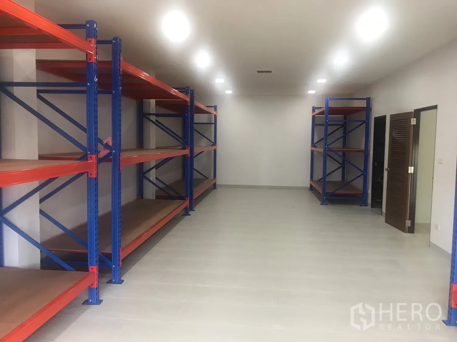 工厂 出售在Krathum Baen, Samut Sakhon - 干净储物间，配置蓝橙色重型货架