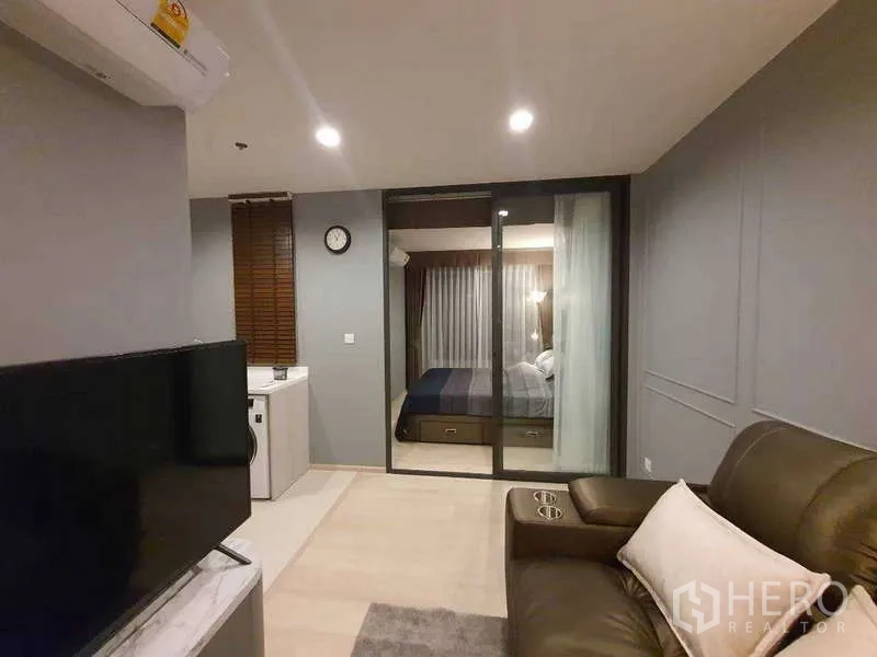 Condominium for rent - Open-plan living room with TV, kitchenette, and sliding door leading to the bedroom.